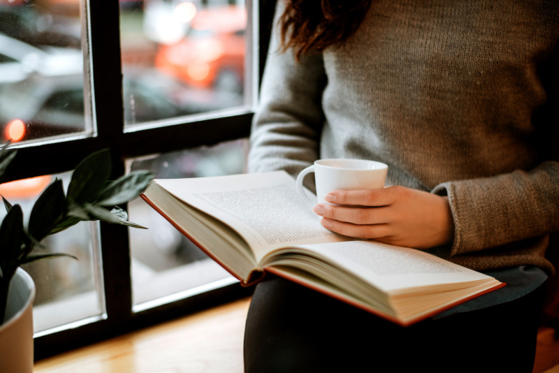 読書をしながらコーヒーを楽しむ女性
